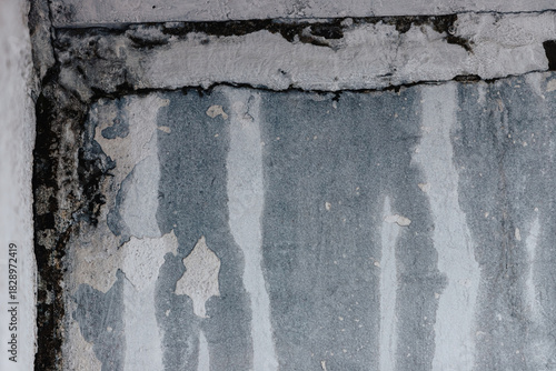 Close-up of severe water damage on an old interior wall corner showing mold, peeling paint, cracks, and moisture stains.