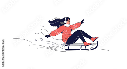 Happy young woman in a cozy winter sweater listening to music on headphones while sledding down a snowy hill.