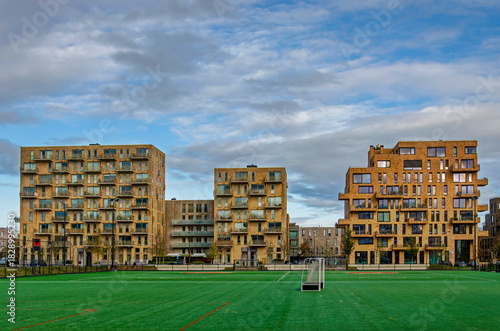 Amsterdam, The Netherlands, November 25, 2025: three residential city blocks overlooking a sports filed in Sports Heroes Neighbourhood