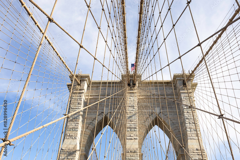 Obraz premium The pedestrian section of the Brooklyn Bridge in New York City is empty of people during the day.