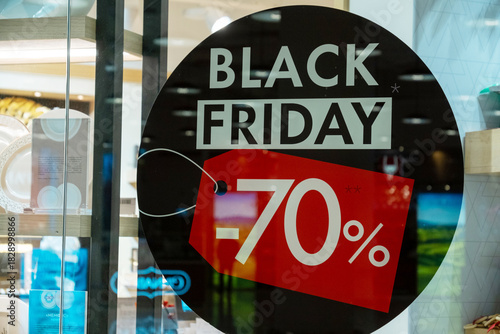 Black Friday sale advertisement with a 70 percent discount displayed on a store window. A red tag highlights the offer, inviting shoppers to take advantage of significant savings.