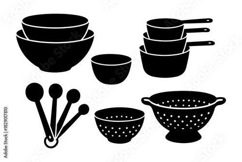 Kitchen utensil set with mixing bowls, measuring cups, colander, and spoons.