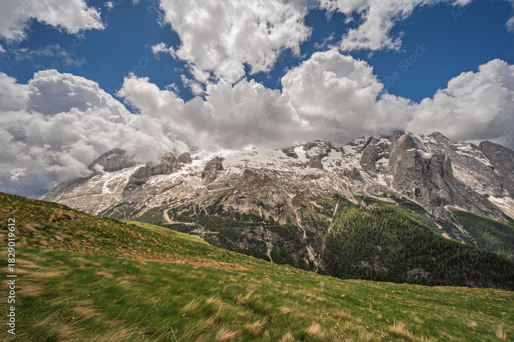 Fototapeta premium Marmolada mountain range seen from the viel del pan trail during a summer cloudy day, Canazei, Dolomites, Italy