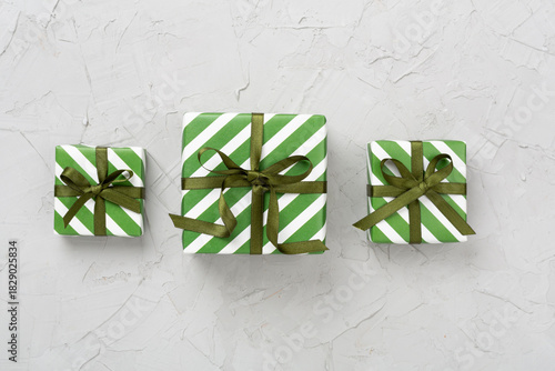 Striped Christmas gift boxes on concrete background, top view
