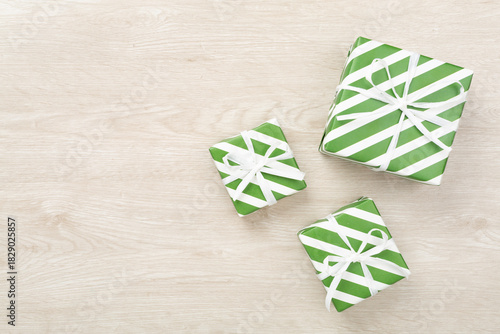 Striped Christmas gift boxes on wooden background, top view
