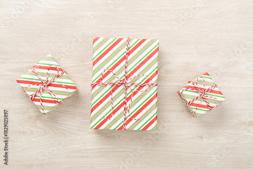 Striped Christmas gift boxes on wooden background, top view