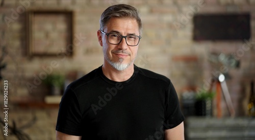 Happy middle aged good looking casual man at home, smiling. Portrait of mid adult, mature age man in glasses,