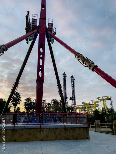 Canvas Print Amusement park rides, thrilling pendulum ride, dramatic sunset sky, evening entertainment
