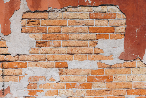 Old brick wall with decaying plaster in Venice