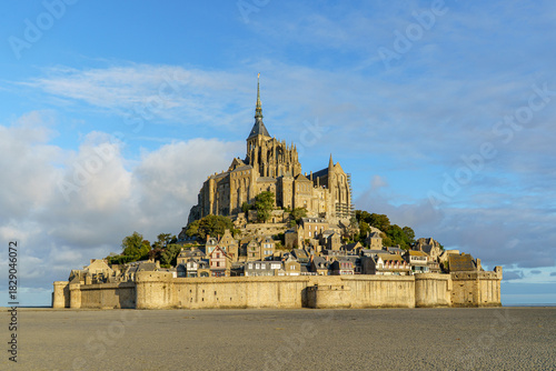 The Abbey of Mont Saint Michel in Normandy, France, photographed early in the afternoon. The sky is blue and cloudy There is no one near the castle The photo was taken in the morning