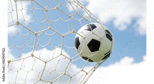 Soccer ball in goal net against blue sky, moment of scoring
