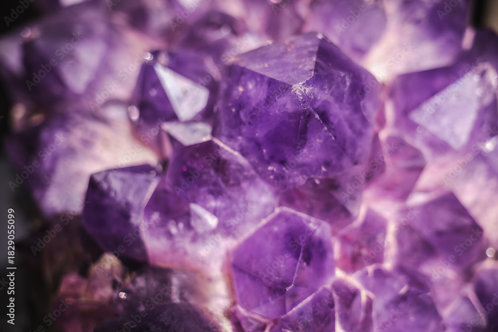 Fototapeta premium Closeup of deep purple amethyst crystals with sharp geometric facets and rich translucent texture