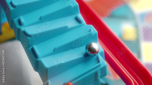 Silver metallic marble rolling down a blue and red slide (board game)