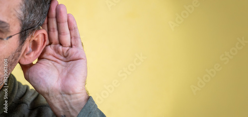 Man cupping ear listening to sound or gossip
