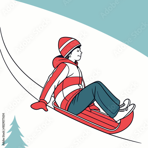 Boy riding a toboggan down a snowy hill