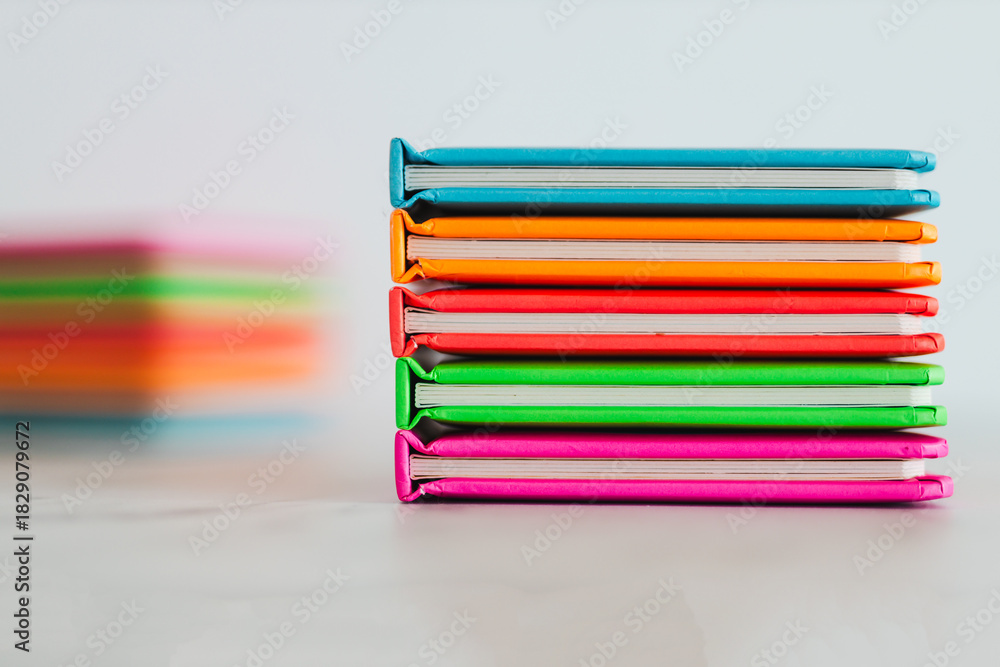Fototapeta premium colourful children books on minimalist setup, concept of learning to read and early education