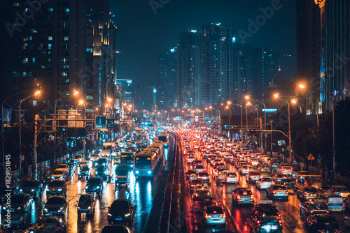 Bustling city highway at night with heavy traffic and illuminated buildings