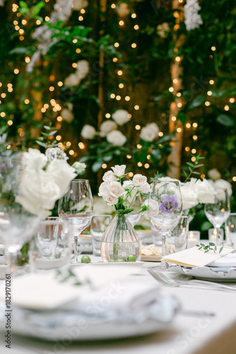 Elegant dining setup with floral decorations and warm lighting for a wedding reception in a beautiful venue