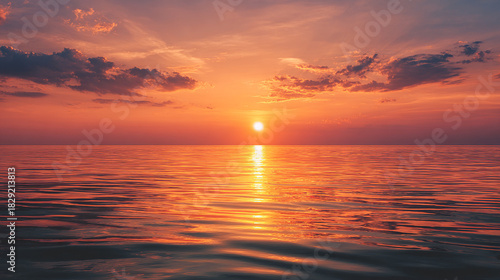 Beautiful sunset view over the calm ocean, vivid orange and pink sky.