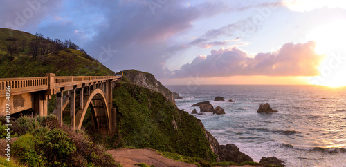 Sunset Rocky Creek Bridge - A panoramic sunset view of Rocky Creek Bridge, known Big Sur Arches, on State Route 1 along the scenic central coastline of California. Big Sur, Monterey, California. 