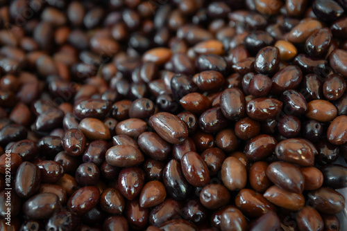 Close-up of glossy black and brown olives in culinary arrangement