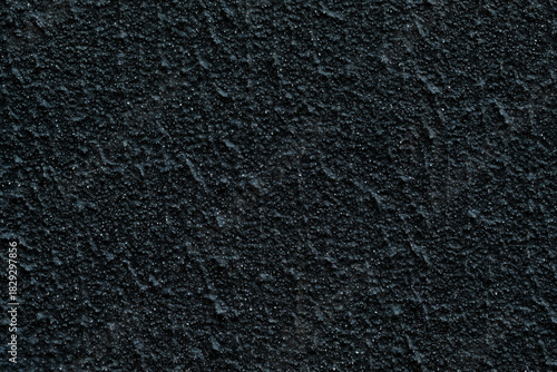 Dark rough asphalt texture background with small pebbles