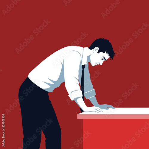 Man in business attire leaning over a desk looking down.