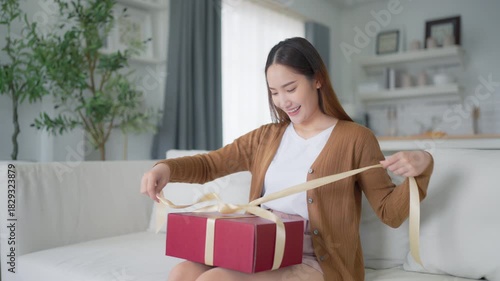 Asian young woman opening a gift box. Happy new year, Thanksgiving