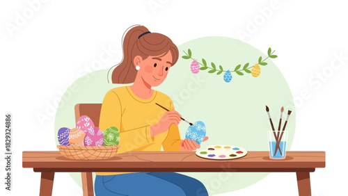 Young woman painting Easter eggs at the wooden table with paintbrush, paint palette. Concept for Easter celebration, holiday preparation and creative activity