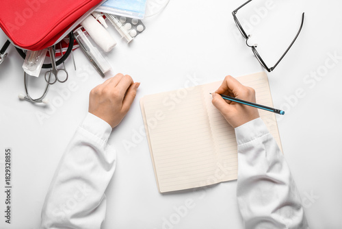 Doctor writing in notebook ...
