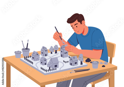 Miniature town painting on table perfect for hobbyist, artist, craftsman, and model enthusiasts. Realistic scene creation, artistry demonstration, diorama inspiration.