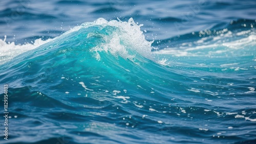 Fototapeta Naklejka Na Ścianę i Meble -  Close up of a turquoise ocean wave breaking with white foam and spray in bright sunlight, blue water texture and motion