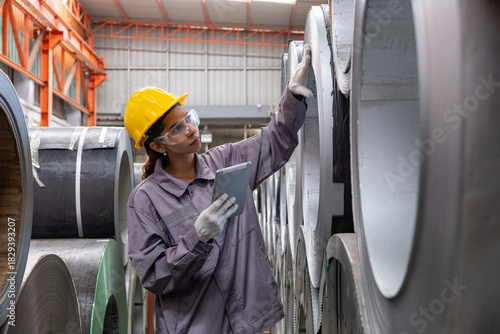 Female engineers inspecting metal sheet production line