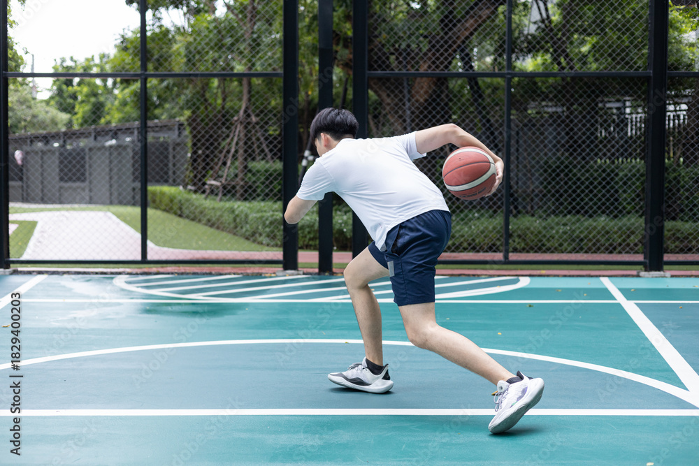Obraz premium Focused Basketball Player Dribbling on Court
