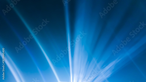 Dramatic white light rays radiate upward from a point source in the center, against a bright and deep electric blue background