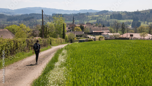 jeune garçon allant à pieds sur une route à un village en France, paysage rural français en Saône-et-Loire