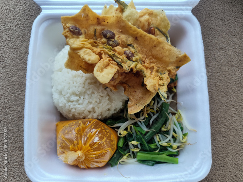 Nasi pecel and sego pecel are typical Javanese Indonesian rice dishes served with pecel sauce, vegetables and others.	