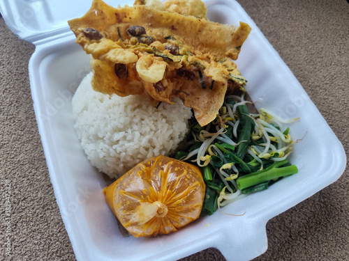 Nasi pecel and sego pecel are typical Javanese Indonesian rice dishes served with pecel sauce, vegetables and others.	