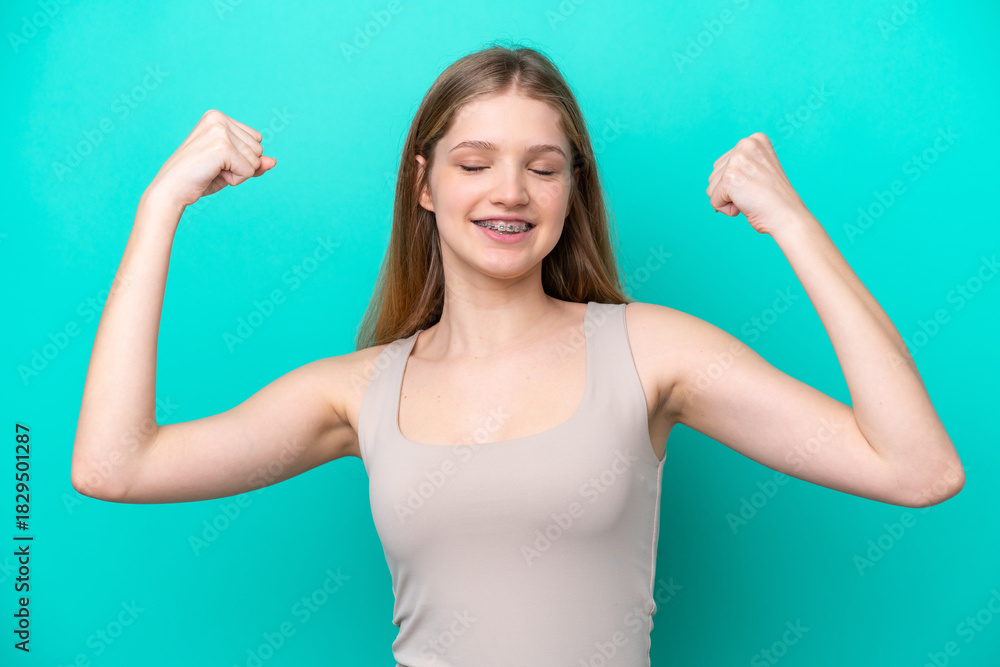 Fototapeta premium Teenager Russian girl isolated on blue background doing strong gesture