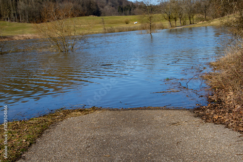 Flooded Road Leading to Submerged Landscape Surrounded by Nature