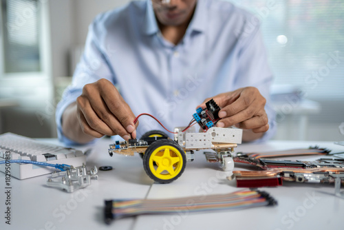 Engineer connecting wires to circuit board, building a robot prototype