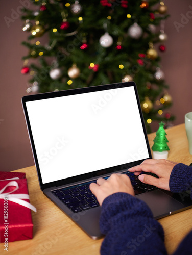 Christmas office holiday workspace with person typing on laptop showing blank screen to represent online celebration digital communication remote work productivity festive season creativity