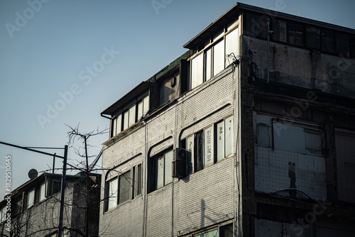 Old and Weathered Brick Building Under Harsh Sunlight and a Blue Sky