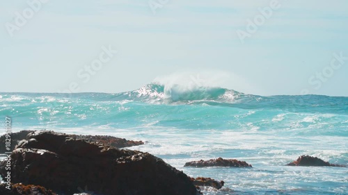 Slow motion, blue giant waves rising on the sea under the sunlight