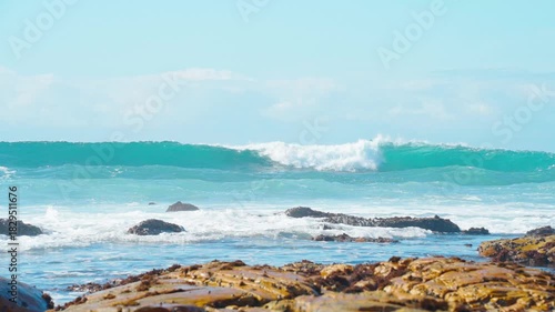 A series of slow-motion shots of beautiful blue waves rolling on the sea under the sunlight