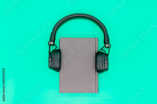 Paper book with headphones, the concept of listening to audiobooks