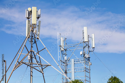 Two tall towers with antennas on top, one of which is a cell phone tower