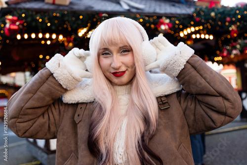 Beautiful woman putting on headphones. Christmas Portrait of Young Blonde Woman