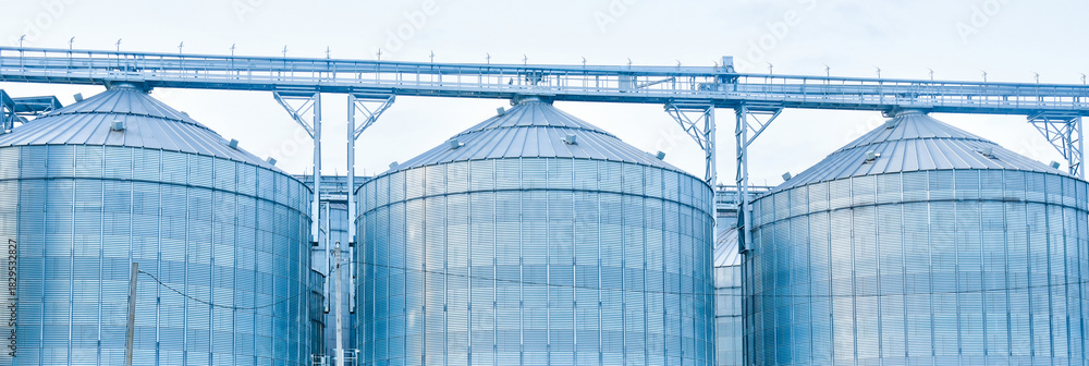 Fototapeta premium Grain silos storing agricultural harvest on a farm industry background