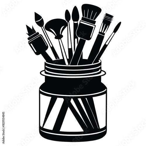 Various paint brushes and artistry tools are placed stylishly within a decorative black jar